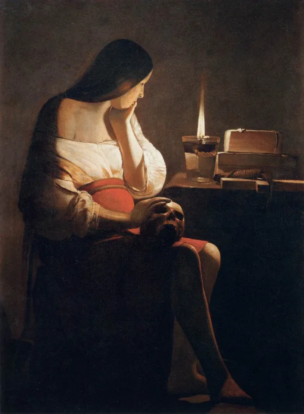 A woman sits before a candle at night, a skull in her lap